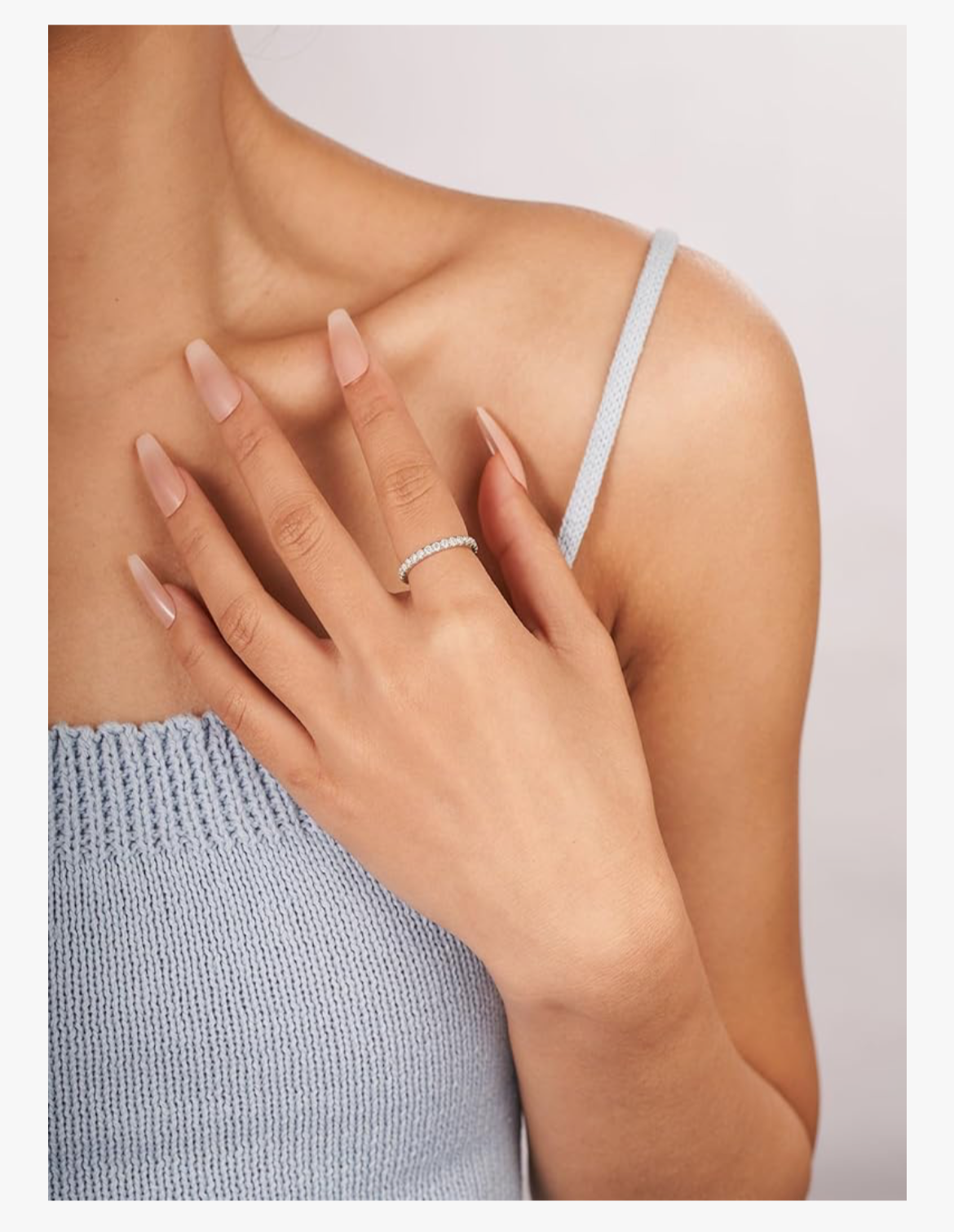 Woman wearing moissanite engagement ring on hand, showcasing elegant lab-made stone jewelry