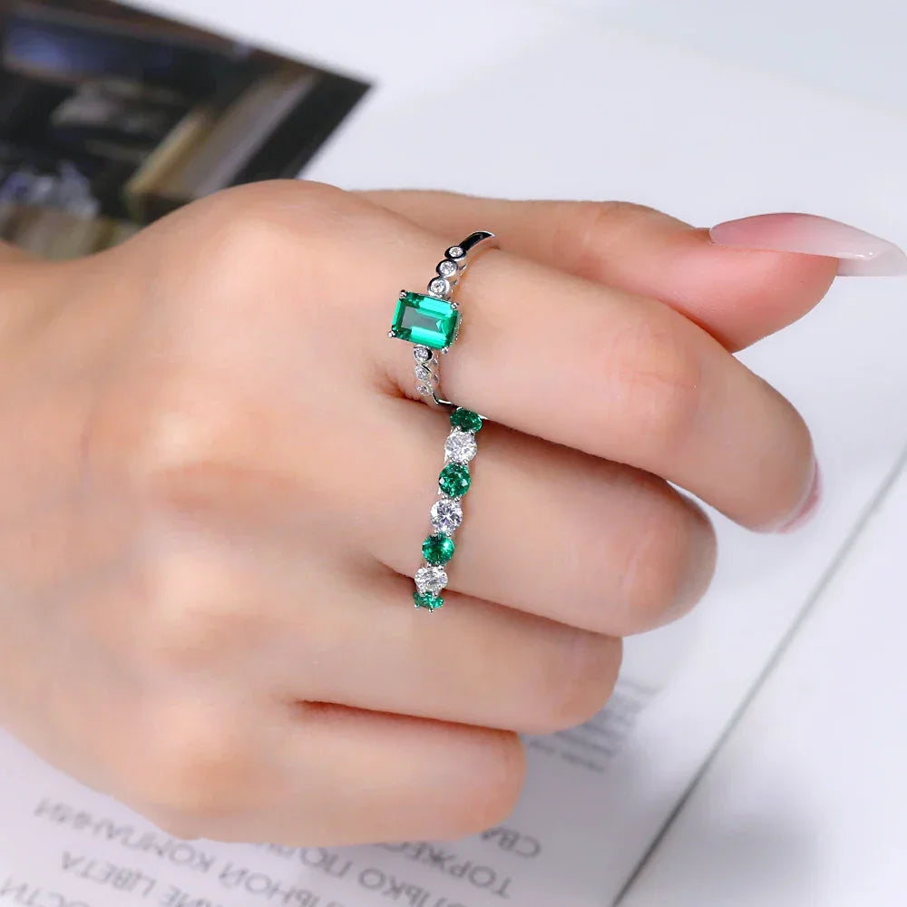 Elegant moissanite and green stone ring on hand, lab-made jewelry from Moissanright