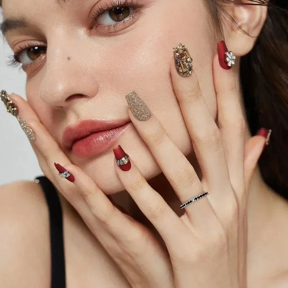 Woman with glittery embellished nails and a moissanite ring, showcasing luxury jewelry