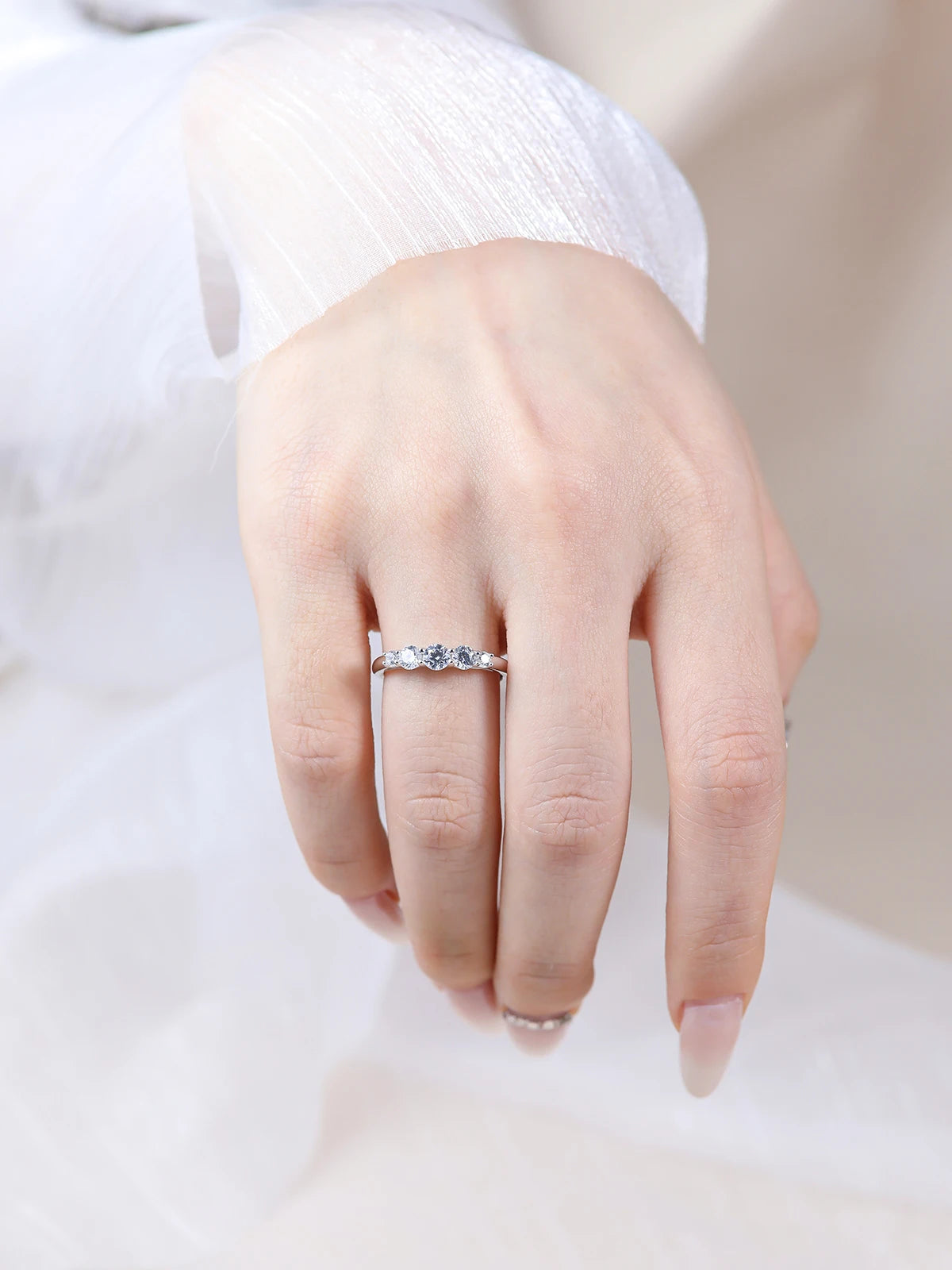 Moissanite engagement ring on hand, silver band, ethical lab-made stone jewelry