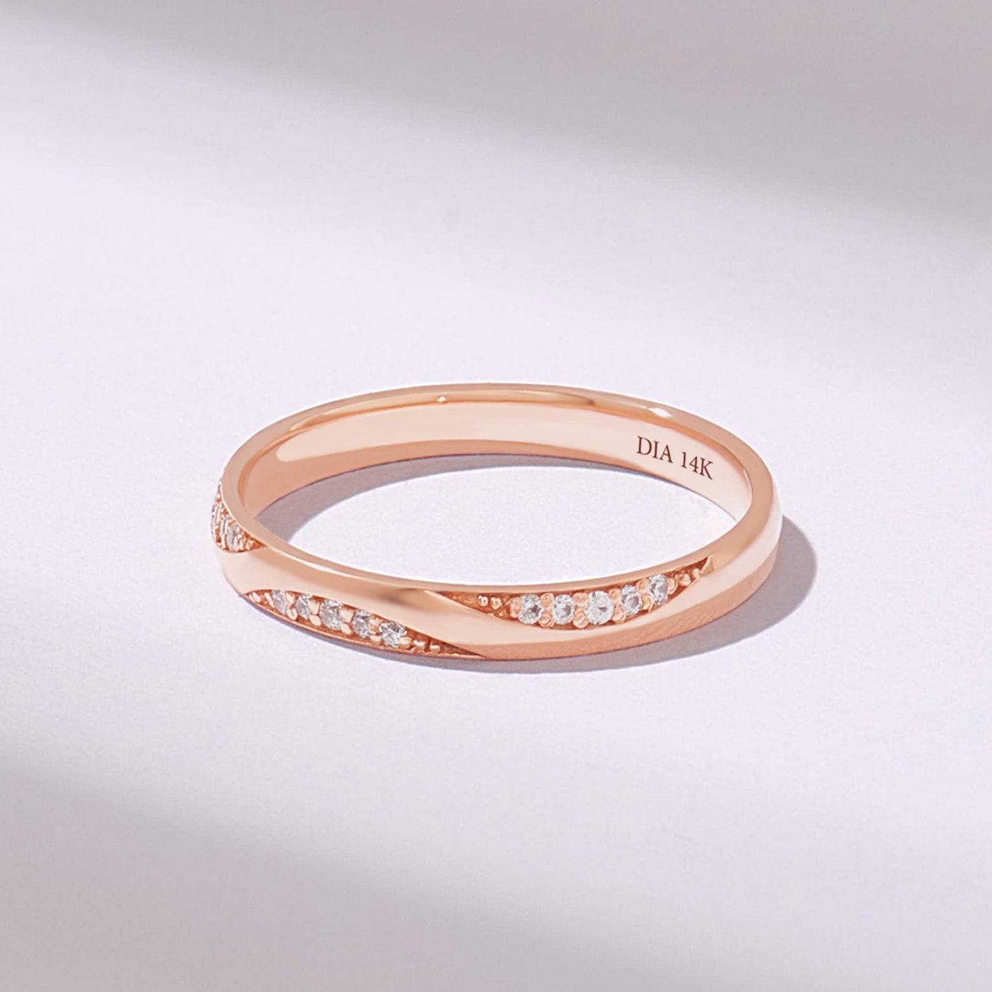 Rose gold moissanite wedding band with pavé lab-made stones on white background