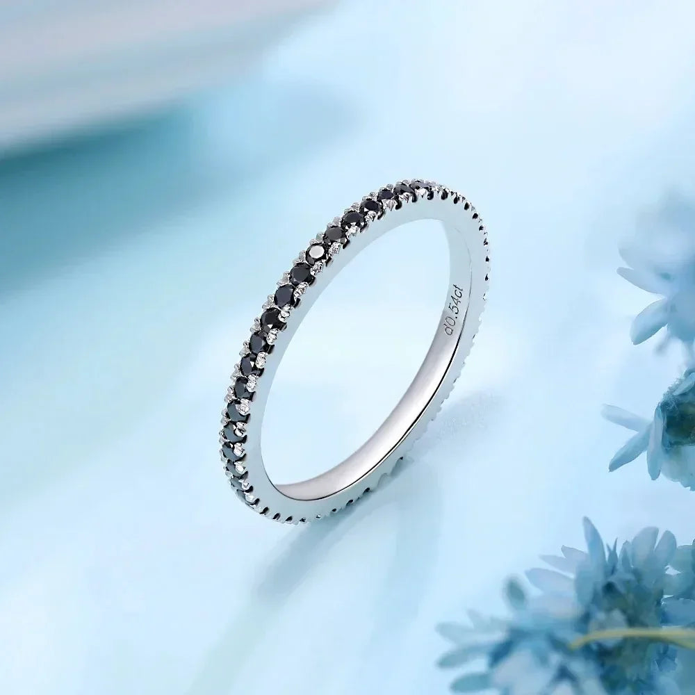 Moissanright black and white moissanite eternity band in white gold, elegant jewelry on blue background