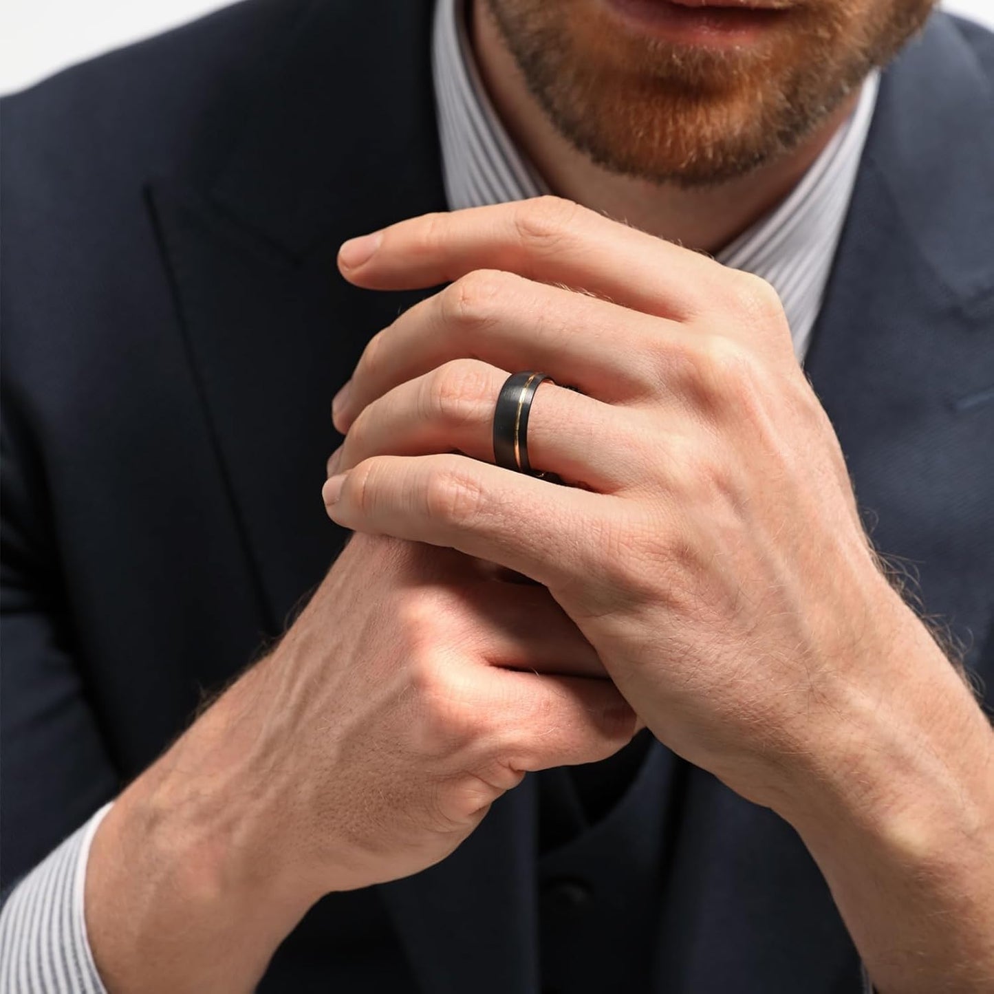 Man in suit wearing a modern black and gold moissanite ring on left hand